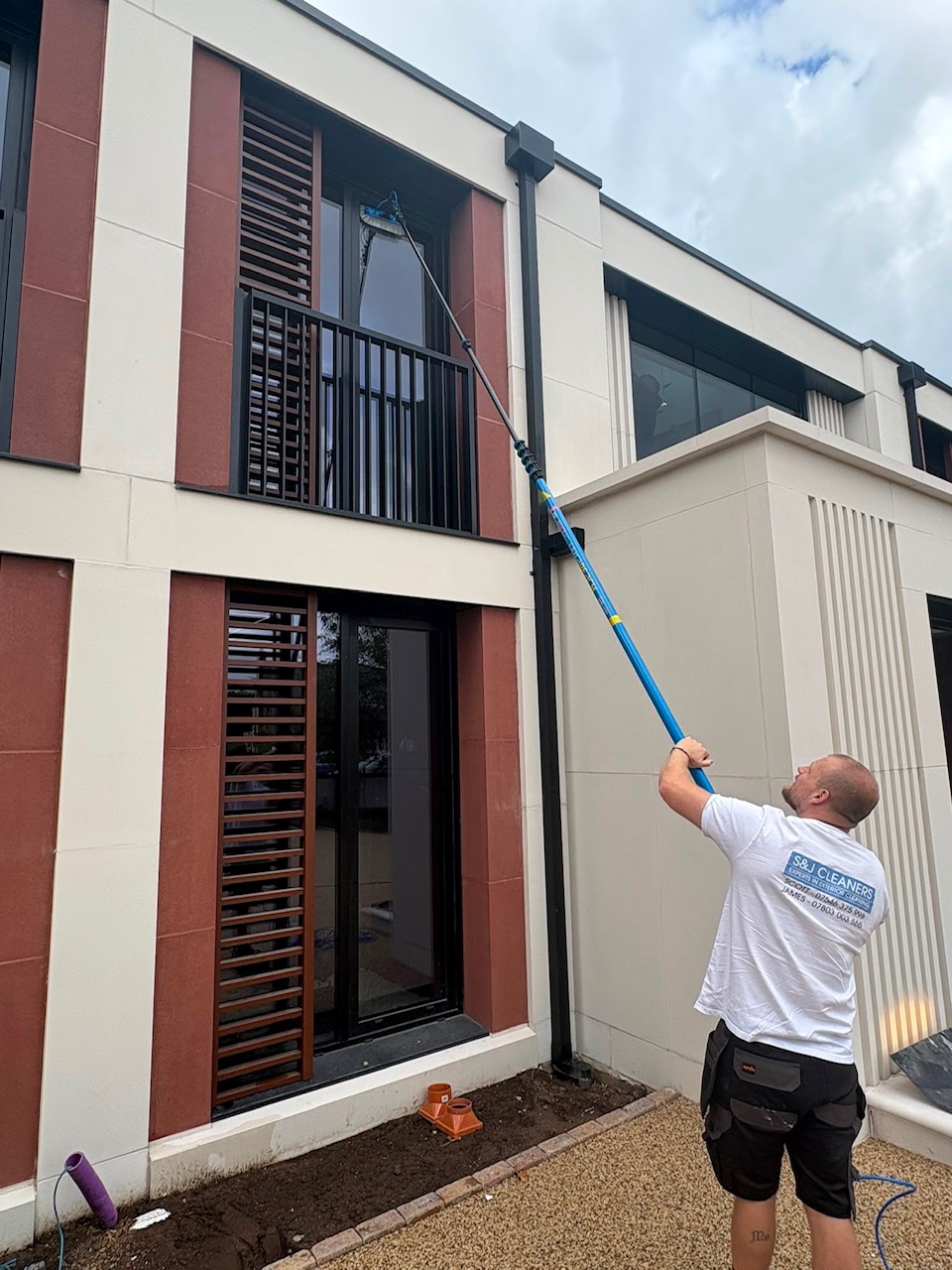 S&J Cleaners pole-fed window cleaning on a modern home